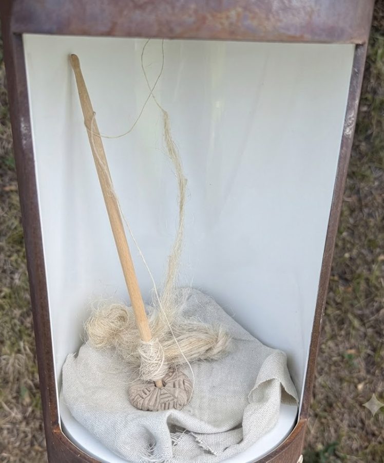 Vollständige Handspindel mit Leinengewebe in einer Vitrine